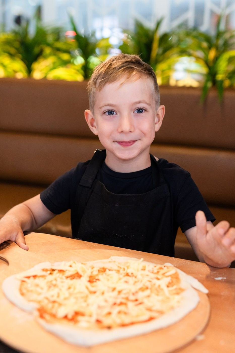 Boy smiling over his pizza