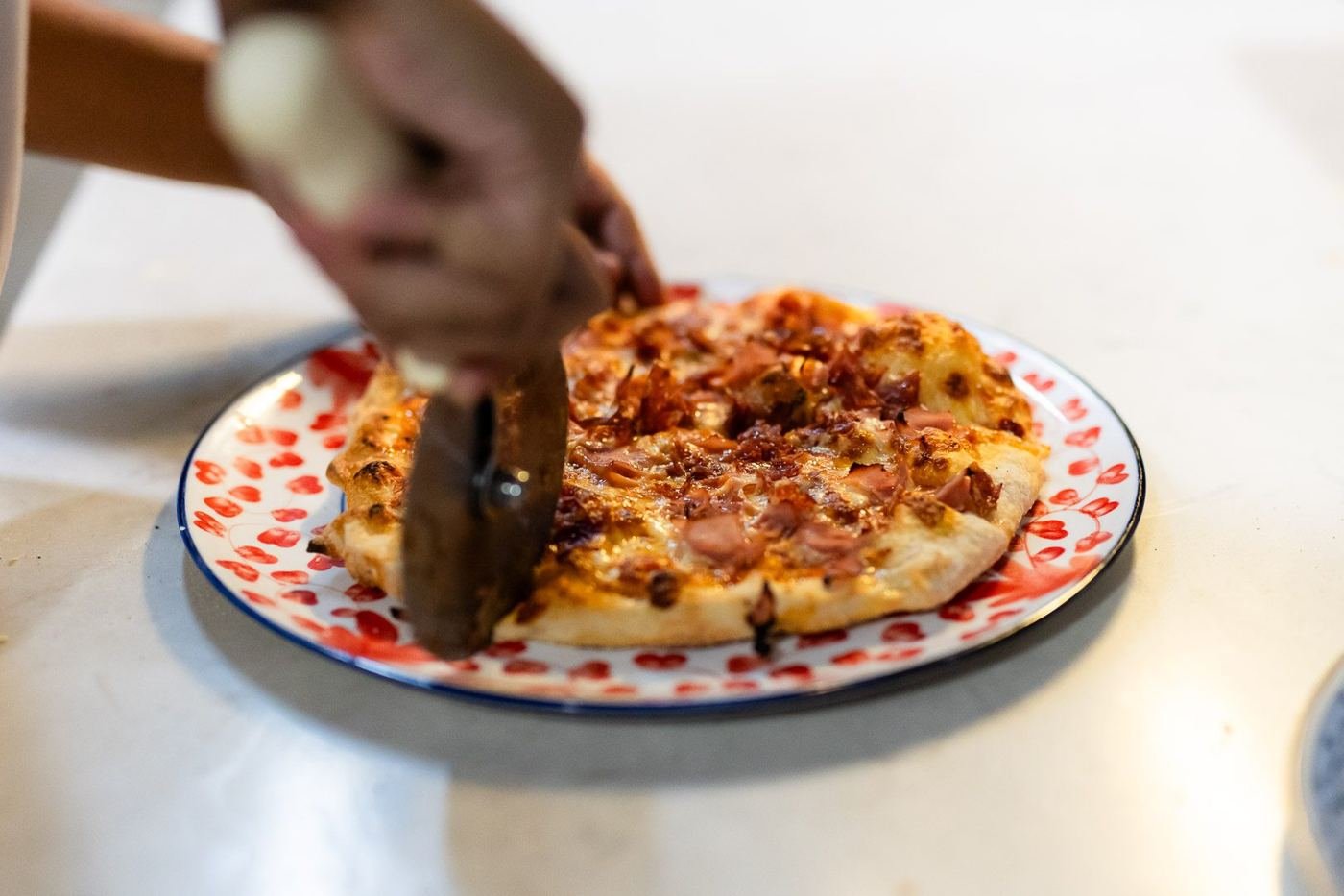 A baked pizza being cut