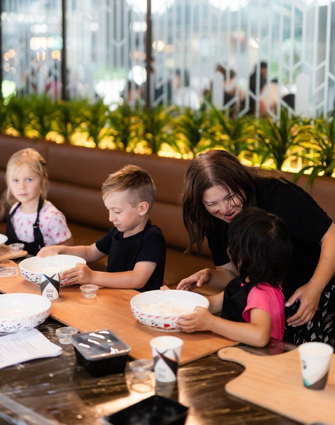 Kids mixing dough with help from our team