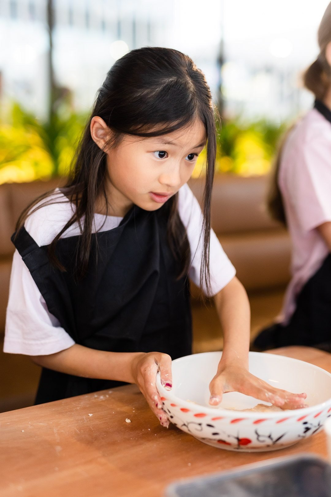 Girl kneading dough in a bowl